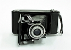 img 0005  Aparat produkowany w latach 1937 - 1941. Film zwojowy o szerokości 6 cm. Przesłona 6,3 – 22. Czasy B, 1/25 – 1/200 s. Ostrość ustawiana poprzez przesuw soczewek w obiektywie. Miech w kolorze czarnym.
